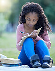 Black woman, studying and park of a student with study books outdoor writing notes. Notebook, learning and girl with university, college and education book on blanket with blurred background