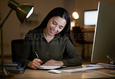 Buy stock photo Happy, writing or business woman on notebook at night for creative idea, journal entry or proposal report. Smile, overtime or manager planning for company strategy or research notes on office desk