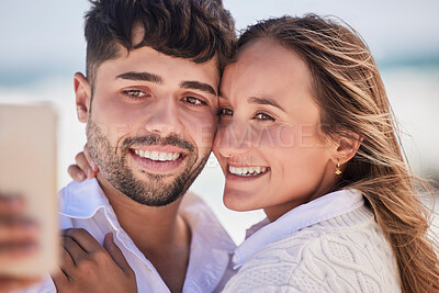 Buy stock photo Selfie, love and couple on a date at the beach for valentines day, romance or anniversary in summer. Happiness, smile and young man and woman hugging while taking picture by the ocean on vacation.