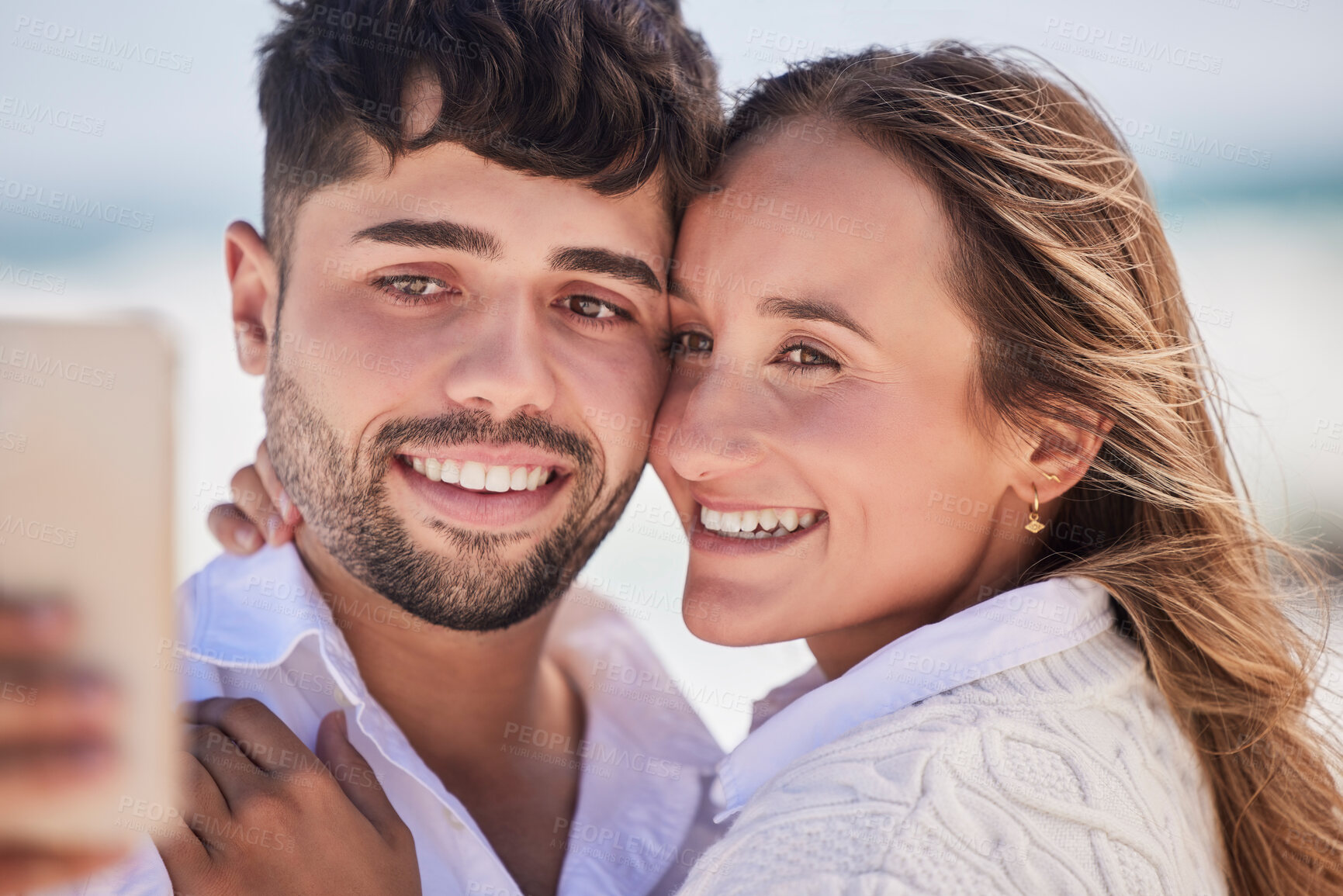 Buy stock photo Selfie, love and couple on a date at the beach for valentines day, romance or anniversary in summer. Happiness, smile and young man and woman hugging while taking picture by the ocean on vacation.