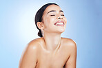 Skincare, beauty and smile of a woman happy about wellness, facial and dermatology. Isolated, blue background and studio with a young model with happiness from self care and spa treatment detox