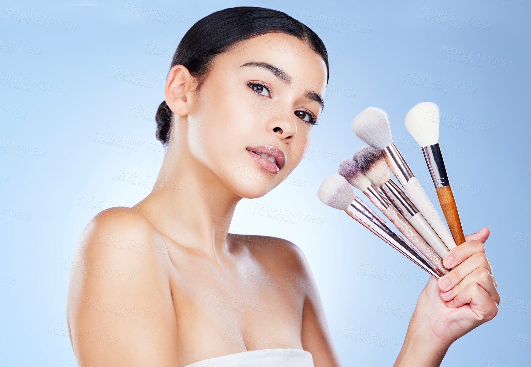 Buy stock photo Makeup, beauty brushes and portrait of woman on blue background for cosmetics, powder and foundation. Cosmetology, salon aesthetic and face of girl with tools for application, wellness and skin glow