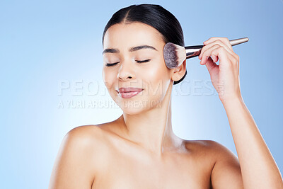 Buy stock photo Makeup, beauty and face of woman with brush on blue background for cosmetics, powder and foundation. Skincare, cosmetology tools and girl smile for facial treatment, luxury salon and application
