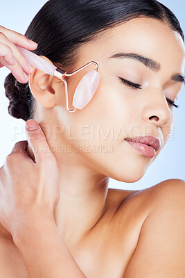 Buy stock photo Woman, face and roller for beauty skincare, cosmetics or facial treatment against a blue studio background. Female hands with rolling tool for cosmetic anti aging routine, clean skin wellness or glow