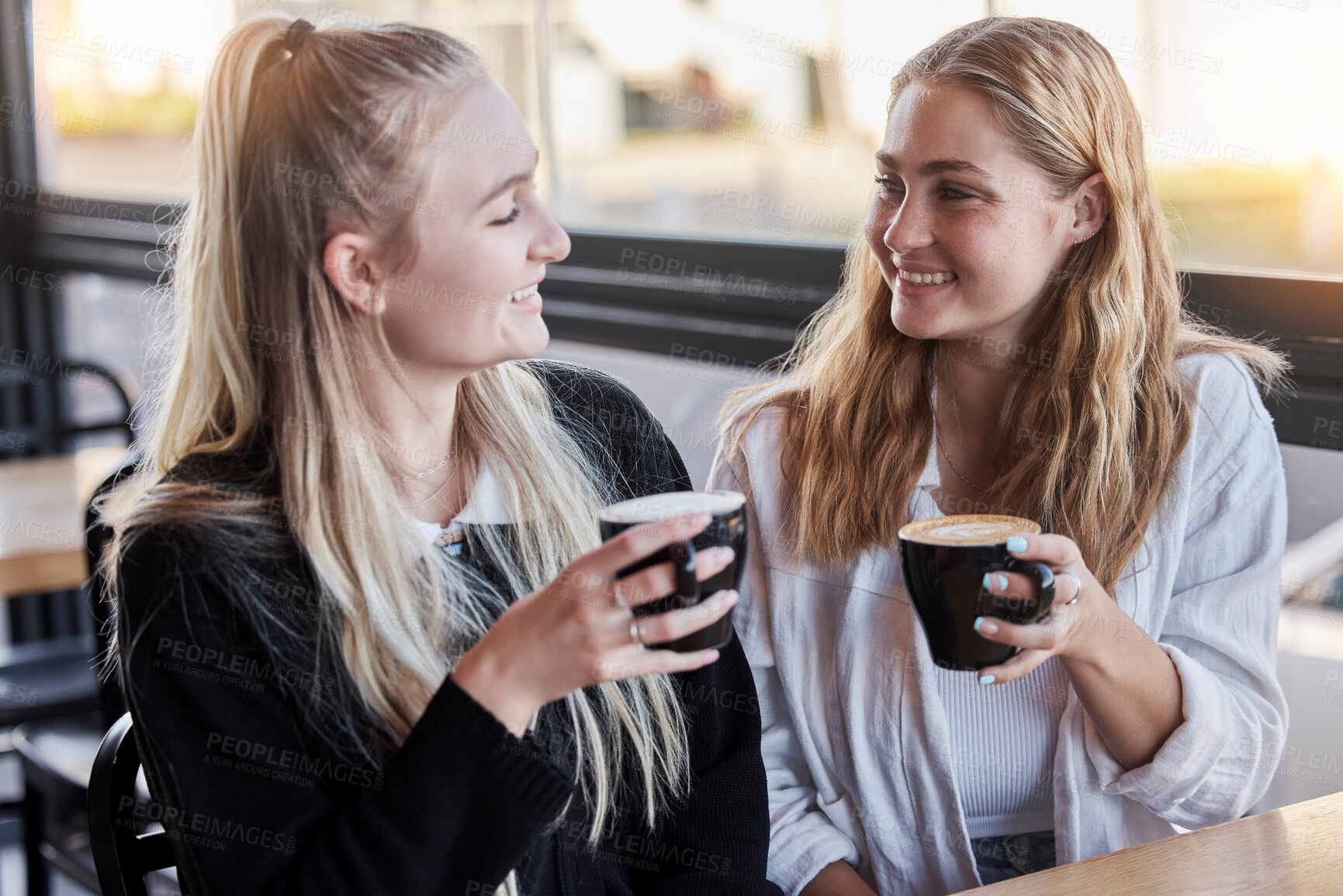 Buy stock photo Coffee shop, couple of friends and happy social date or conversation in morning for gen z lifestyle. Young people or youth women talking together with latte cup in cafe or restaurant on student break