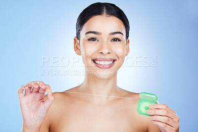 Buy stock photo Face, floss teeth and dental with woman, hygiene and beauty with grooming and container on blue background. Hands, string and oral care product, healthy gums with fresh breath, health and portrait