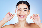 Face, flossing teeth and hygiene with woman, dental and beauty with grooming and mouth care on blue background. Hands, string and healthy gums with fresh breath, health and skin glow in portrait