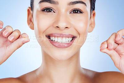 Buy stock photo Face, flossing teeth and dental with woman, hygiene and beauty with grooming and mouth care on blue background. Hands, string and healthy gums with fresh breath, health and skin glow in portrait