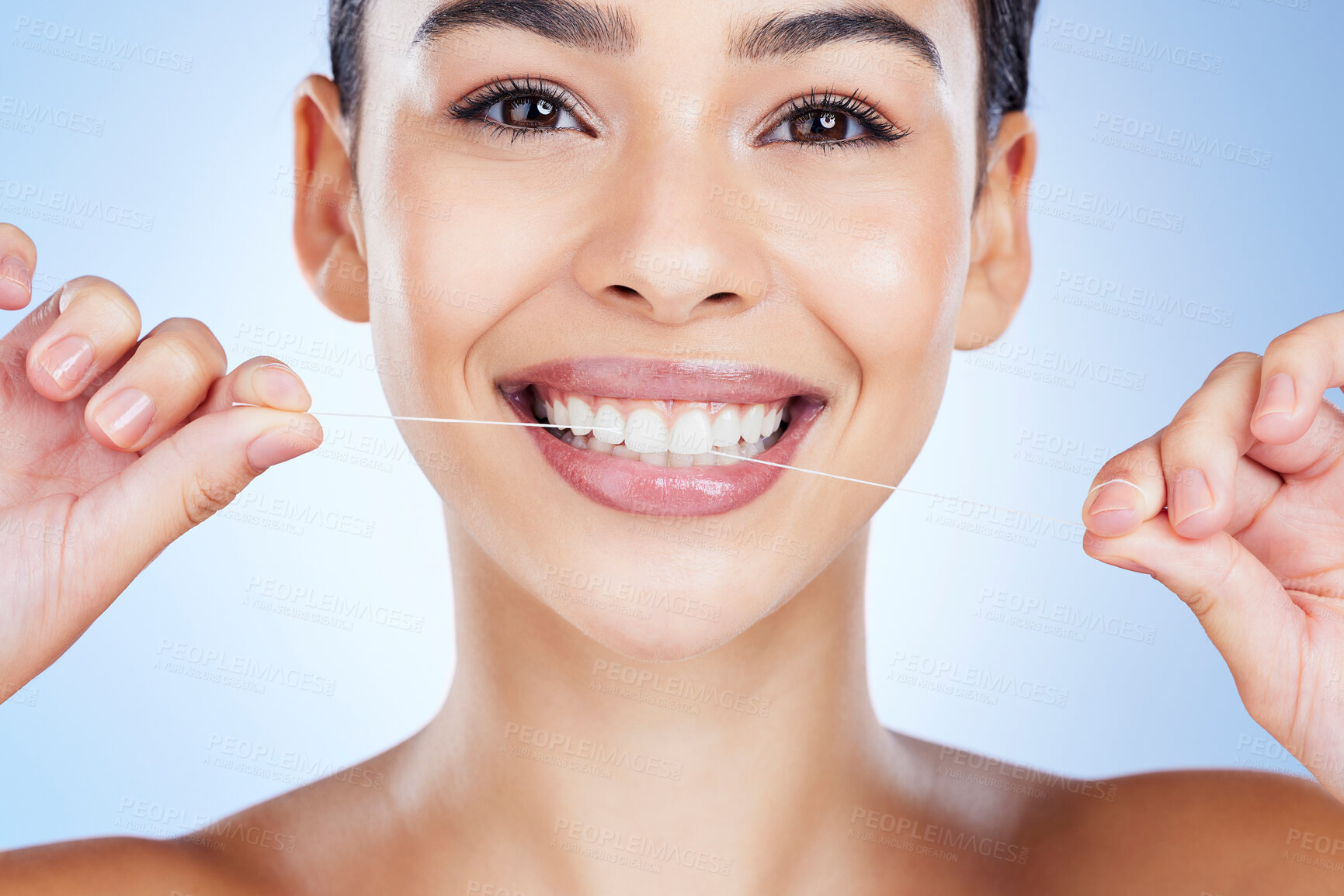 Buy stock photo Face, flossing teeth and dental with woman, hygiene and beauty with grooming and mouth care on blue background. Hands, string and healthy gums with fresh breath, health and skin glow in portrait