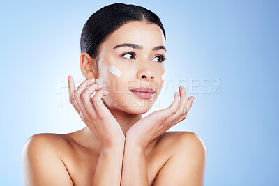 Buy stock photo Woman, face and skincare moisturizer, cosmetics or beauty against a blue studio background. Female applying cosmetic product, lotion or cream for facial treatment or self love or care on mockup