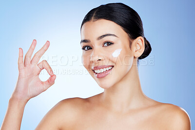 Buy stock photo Woman, face and OK emoji for skincare moisturizer, cosmetics or beauty against blue studio background. Portrait of female hand showing okay sign for product, lotion and perfect skin cream for facial