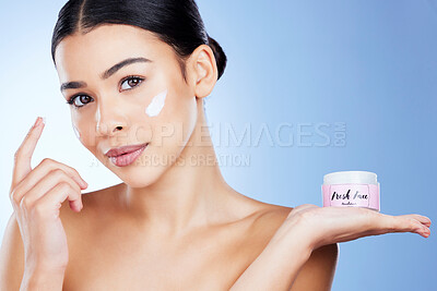 Buy stock photo Skincare, product and portrait of a woman with cream isolated on blue background in a studio. Cosmetic, treatment and girl applying a lotion, sunscreen or moisturizer on face for promotion with space