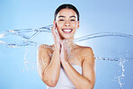 Beauty, skin care and portrait of woman with water splash for facial results on blue background. Aesthetic model person face happy with cosmetics or makeup for health, wellness and dermatology clean