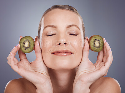 Buy stock photo Kiwi, woman and beauty for natural skincare, cosmetics and food product on studio background. Happy mature model, organic fruit and vitamin c nutrition of vegan diet, detox wellness or face aesthetic