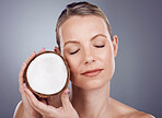 Coconut, woman and skincare for wellness in studio, healthy food and aesthetic benefits. Beauty model, tropical fruits for oil and natural cosmetics of mature facial nutrition, glow or spa background