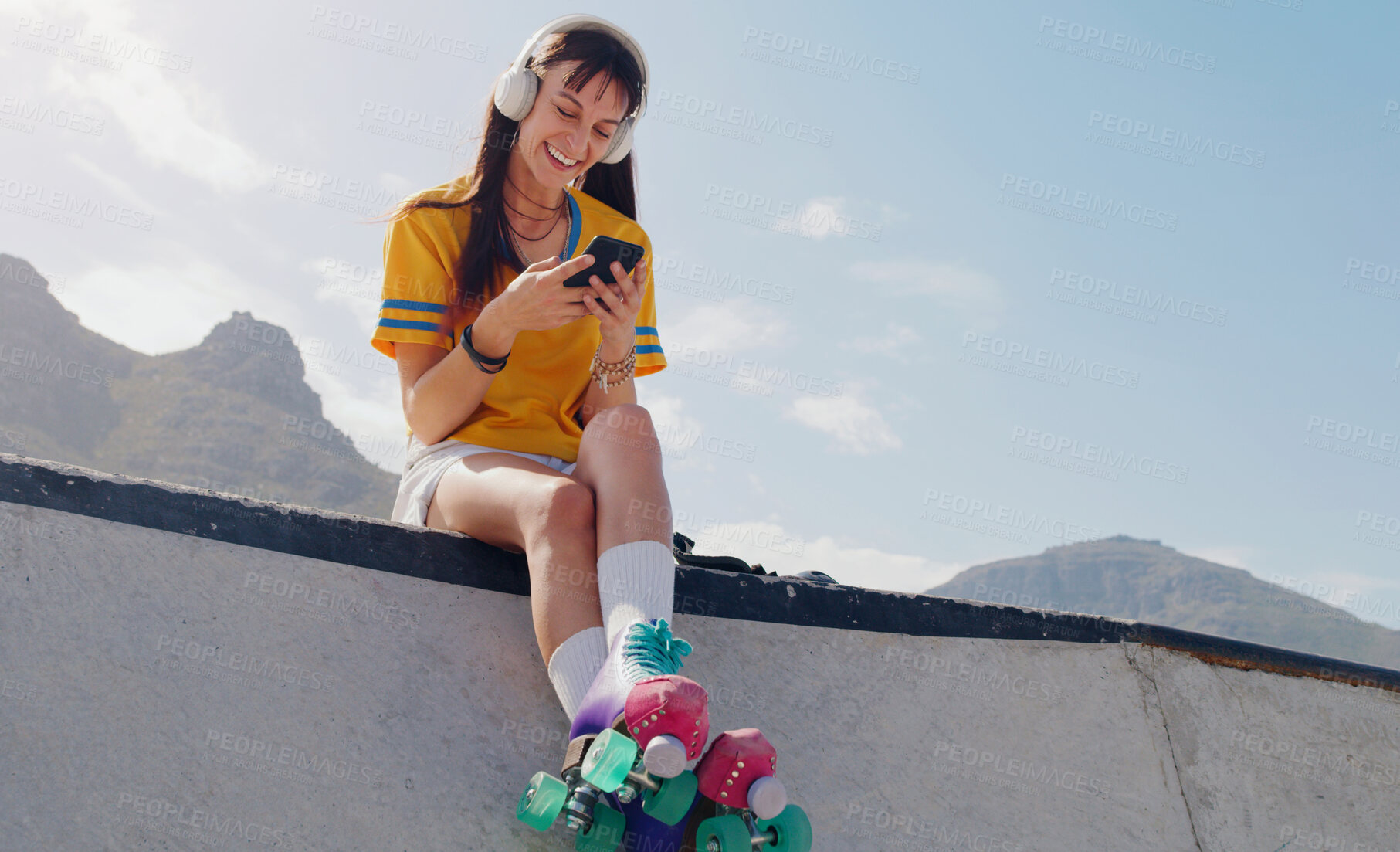 Buy stock photo Smile, phone and music with woman and roller skates for skating, streaming and social media app. Technology, headphones and sports with girl in skate park for internet, mobile radio and fitness