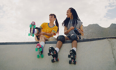 Buy stock photo Rollerskate, skatepark and fun with a couple of friends sitting outdoor on a ramp for recreation together. Fitness, diversity or sports with a man and woman bonding outside for an active hobby