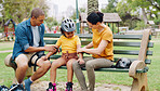 Parents, park bench and helmet with kid, help and safety for skating, rollerskate or bike. Interracial family, mom and dad with helping hand, teaching and girl kid for bonding, learning and exercise