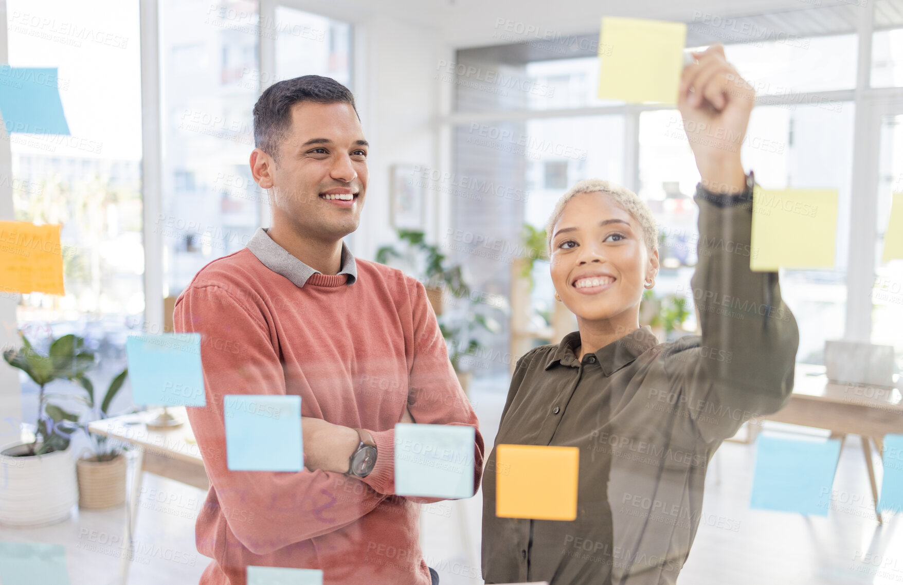 Buy stock photo Creative people, planning schedule and strategy in brainstorming on glass wall at the office. Happy man and woman employees in project plan, tasks and post it with smile for sticky note or startup