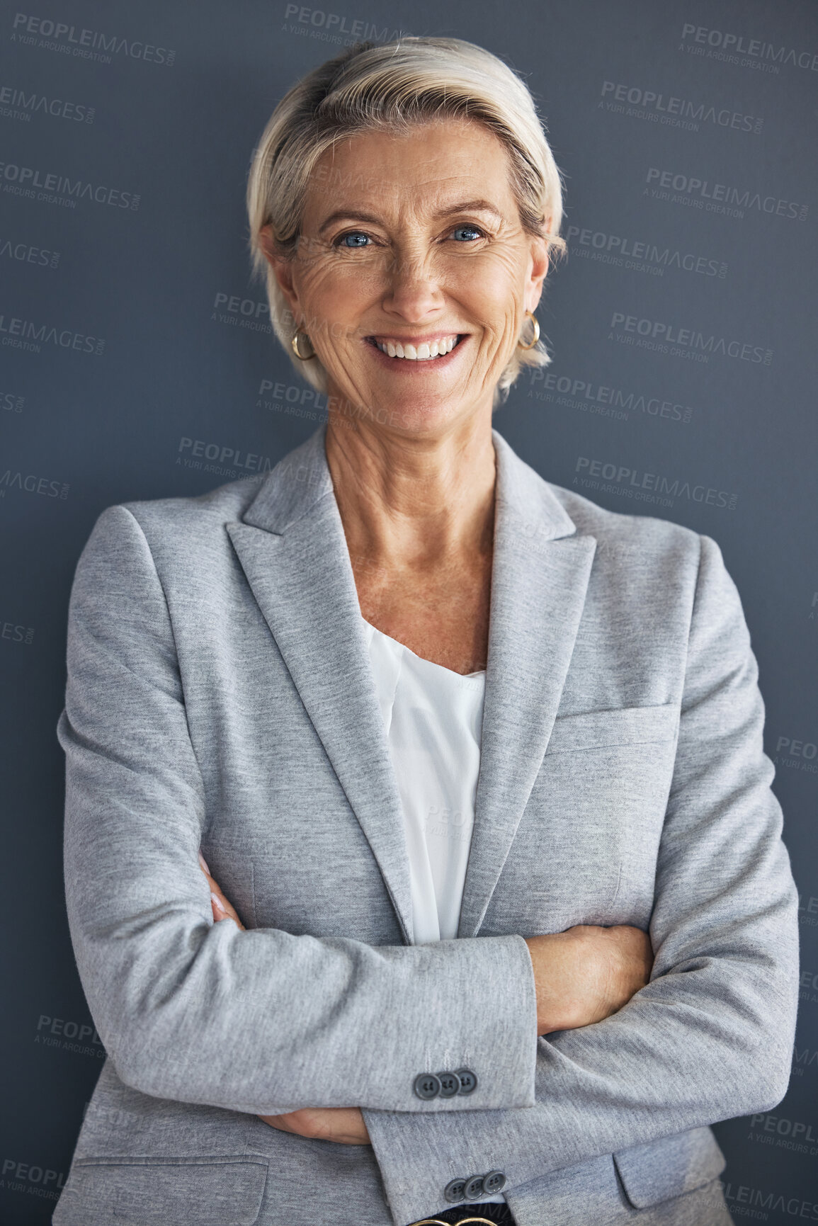 Buy stock photo Smile, confidence and portrait of mature businesswoman with arms crossed isolated on blue background. Success, vision and leadership, happy senior woman in corporate management standing in studio.
