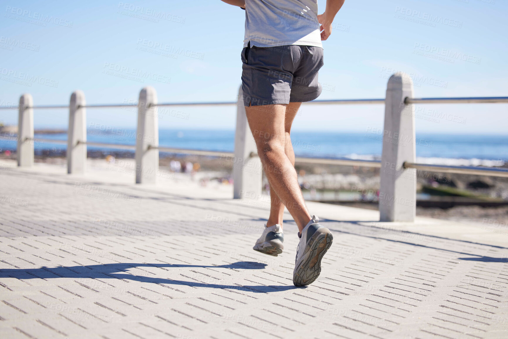 Buy stock photo Fitness, sports and legs of man running by ocean for wellness, performance and athlete endurance. Nature, motivation and feet of male runner by sea for exercise, marathon training and cardio workout