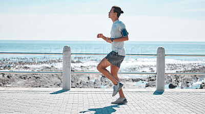 Buy stock photo Fitness, sports and man running by ocean in action for wellness, performance and athlete endurance. Nature, motivation and male runner by sea for exercise jog, marathon training and cardio workout