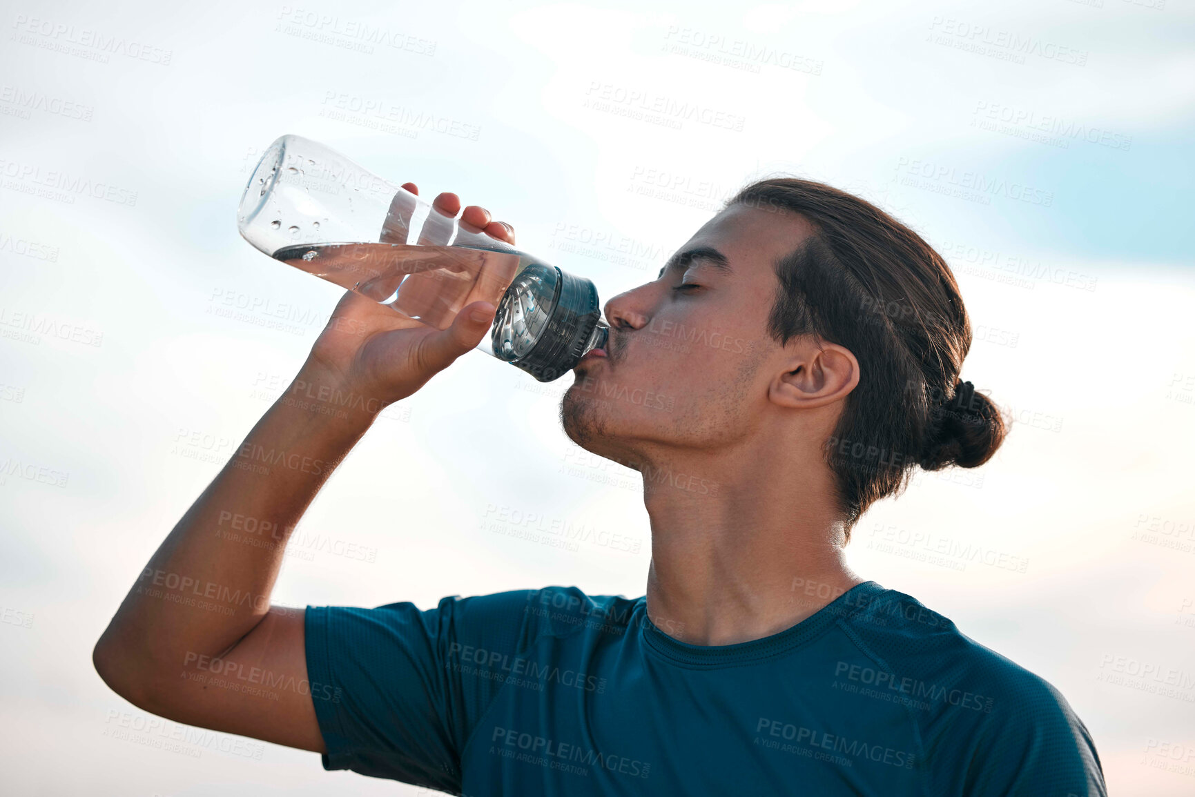 Buy stock photo Fitness, drinking water and man with training, exercise and workout for balance, healthy lifestyle and thirsty. Male, athlete and runner with liquid, aqua and hydration after practice, sunset and sky