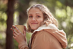 Portrait, coffee and woman relax in forest, smile and happy in nature on bokeh background. Camping, face and tea break for girl in woods, peaceful and quiet while enjoying travel, vacation or trip