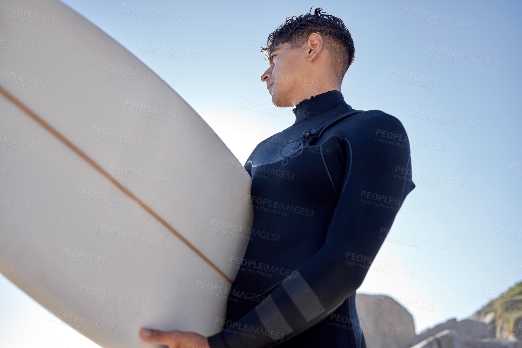 Buy stock photo Surfing, beach and man with blue sky outdoor for water sports, training and exercise. Surfboard, morning workout and sea with summer sun and young surfer ready for sport and freedom at the ocean