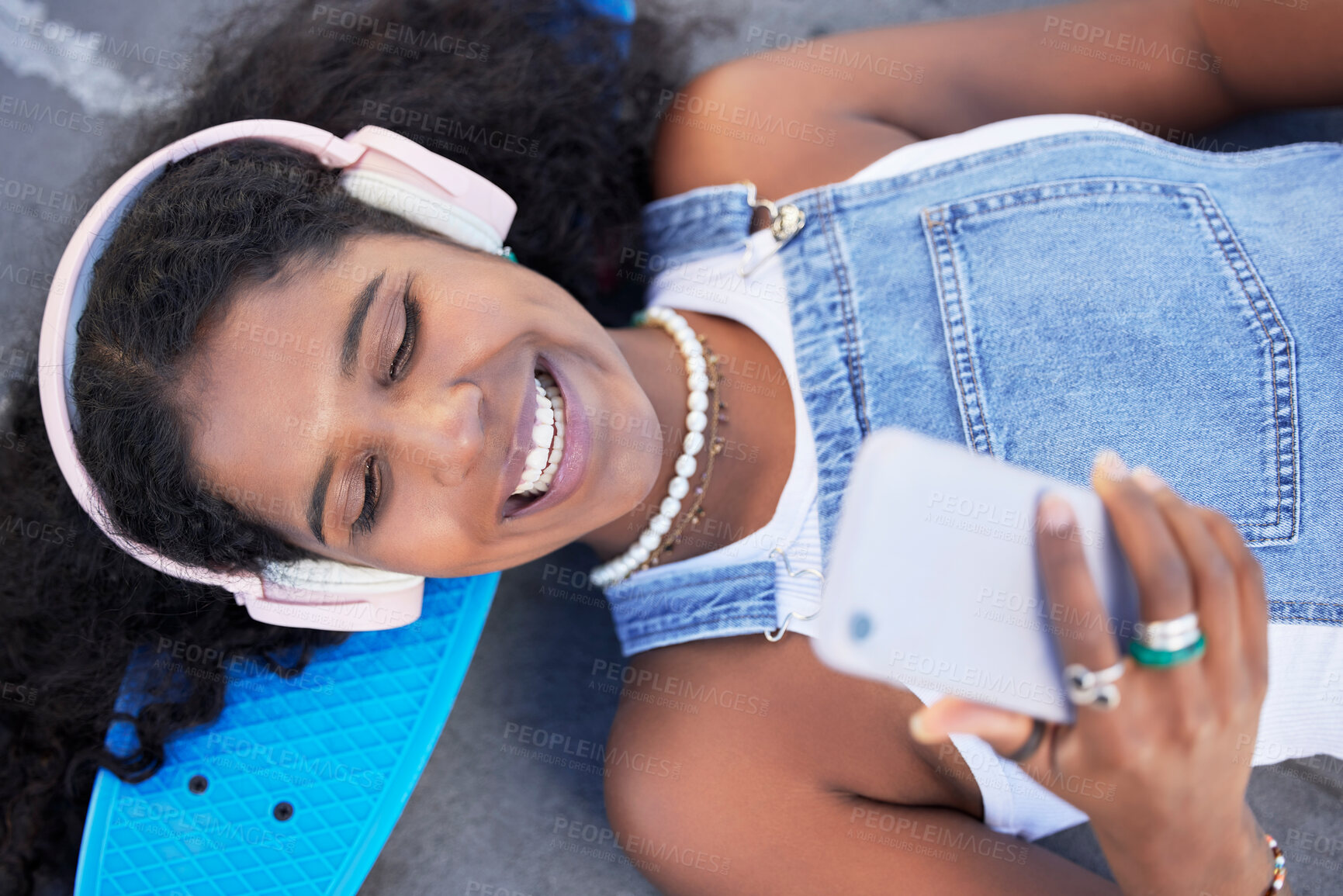 Buy stock photo Top view, music headphones and black woman with phone for streaming podcast and radio. City technology, cellphone and happy female laughing with 5g smartphone for social media or internet browsing