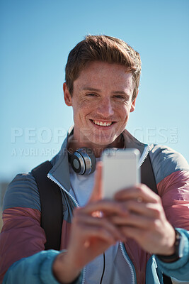 Buy stock photo Selfie, travel and man smile outdoor with happiness from travel and freedom by blue sky. Profile picture, social media update and web networking of young person with mobile connection in the sun