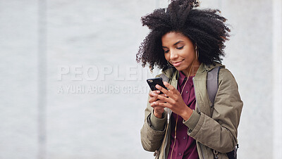 Buy stock photo Black woman, phone and earphones in city, texting and smile for flirt chat, online date or meme on app. Young gen z girl, african student and travel in metro with smartphone for social media with iot