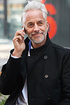 Mature businessman using smartphone talking on mobile phone in city