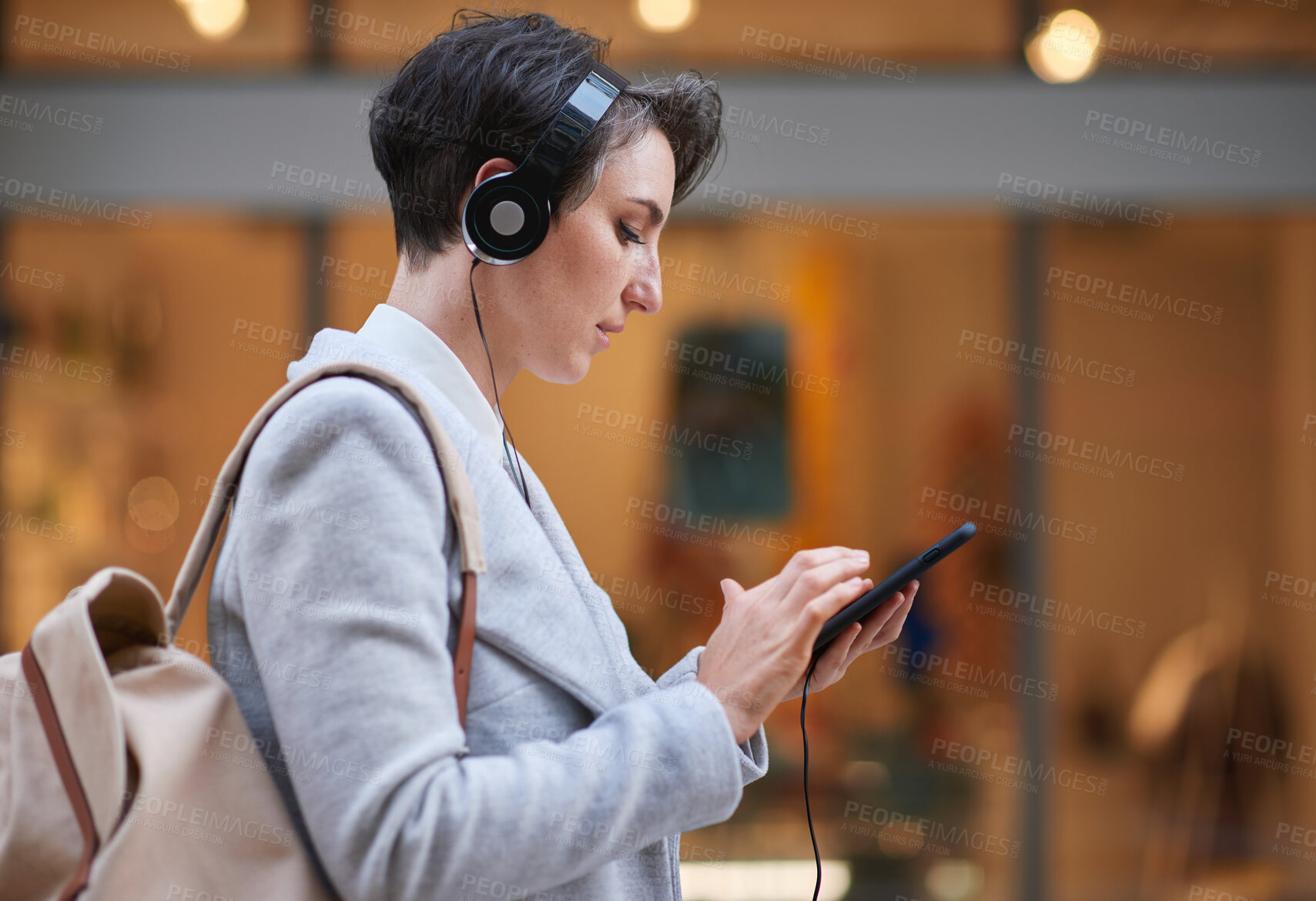Buy stock photo Phone, music headphones and business woman in city streaming radio or podcast. Urban street, cellphone and female entrepreneur with 5g mobile smartphone for networking, social media or web browsing.