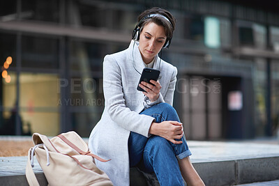 Buy stock photo Phone, headphones and business woman in city streaming radio, podcast or music. Technology, cellphone and female entrepreneur with 5g mobile smartphone for networking, social media or web browsing.