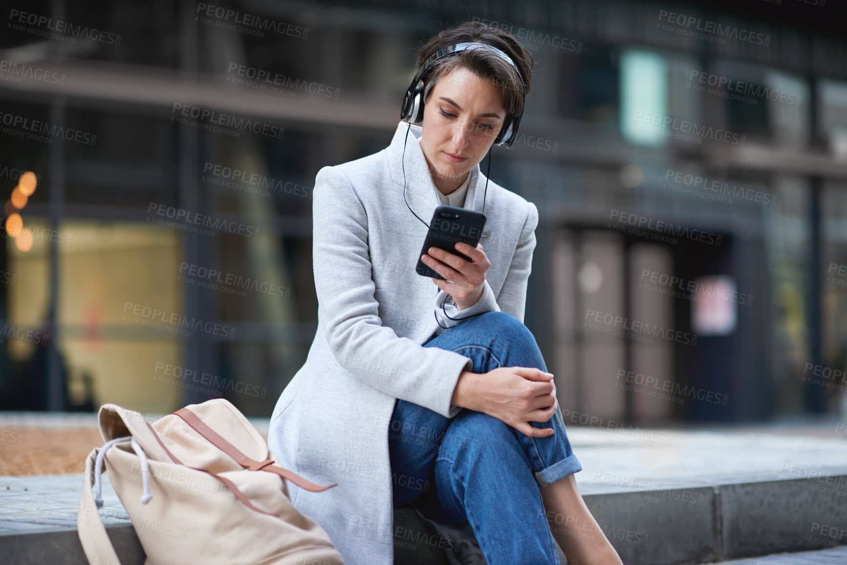 Buy stock photo Phone, headphones and business woman in city streaming radio, podcast or music. Technology, cellphone and female entrepreneur with 5g mobile smartphone for networking, social media or web browsing.