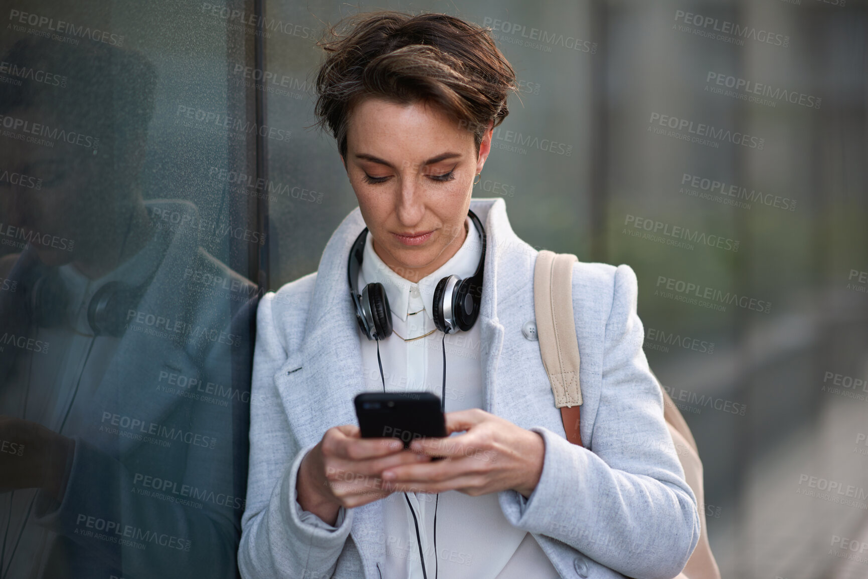 Buy stock photo Woman, phone and social media with communication outdoor, chat or email with headphones, travel to work and mockup space. Young creative in city, mobile app with technology and 5g network in Boston