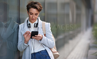 Buy stock photo Woman, smartphone and social media with communication outdoor, chat or email with headphones, travel to work and mockup space. Young creative in city, mobile app with technology and 5g in Boston