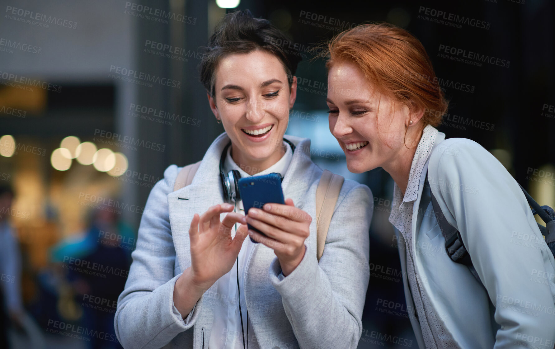 Buy stock photo Friends, laughing and business people with phone in city for social media in street at night. Technology, smartphone and happy women or coworkers laugh at funny meme, comic joke and internet browsing