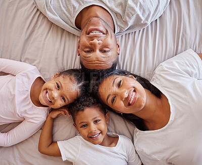 Buy stock photo Portrait, family and children on a bed with their parents, lying together in the morning at home overhead. Love, relax or bedroom with a mother, father and kids bonding over the weekend in a circle