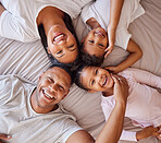 Portrait, family and kids on a bed with their parents, lying together in the morning at home overhead. Love, relax or bedroom with a mother, father and children bonding over the weekend in a circle