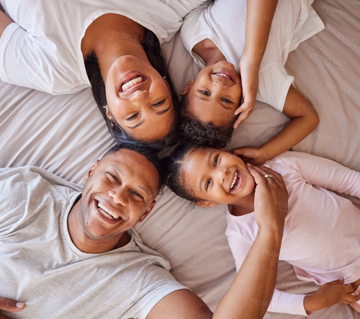 Buy stock photo Portrait, family and kids on a bed with their parents, lying together in the morning at home overhead. Love, relax or bedroom with a mother, father and children bonding over the weekend in a circle