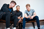 Sports, smartphone and friends relax in locker room after practice, exercise and training in gym. Wellness, fitness club and men on phone listening to music, audio and share track rest from workout