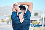 Back of man, stretching and exercise in city for wellness, training and healthy lifestyle goals. Sports person warm up arms, body and outdoor workout for fitness, energy or marathon running in street