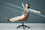 Portrait, chair and celebration of business woman for success, goals or achievements in office. Freedom, carefree and smile of happy Asian female riding on seat, laughing at joke or celebrate targets
