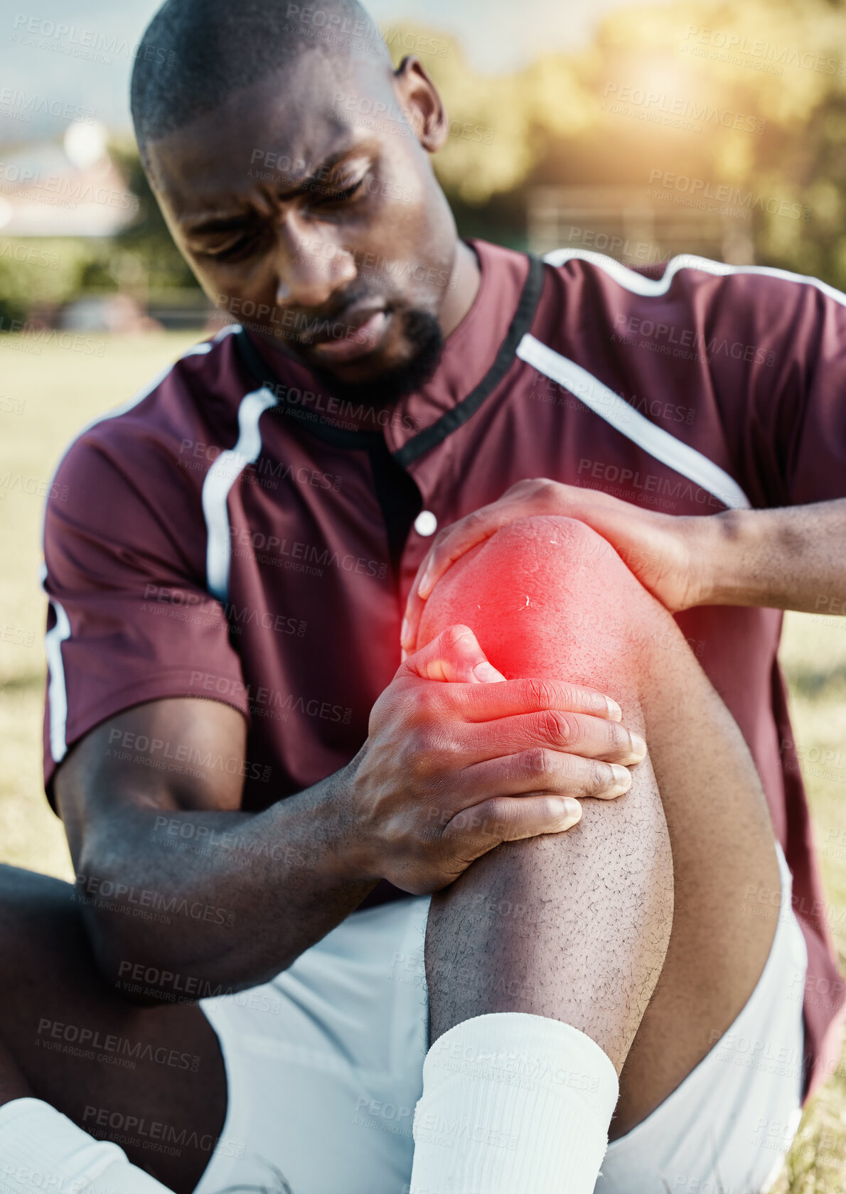 Buy stock photo Injury, soccer player and athlete with pain on knee on a sports field, hurt and inflammation on his leg during a match. Black man, sportsman and person playing football with red overlay in fitness