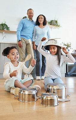 Buy stock photo Funny, playing and children with pots for drums with parents watching with love in their home kitchen. Family, happy and crazy playful siblings making noise on metal to play a sound for mom and dad