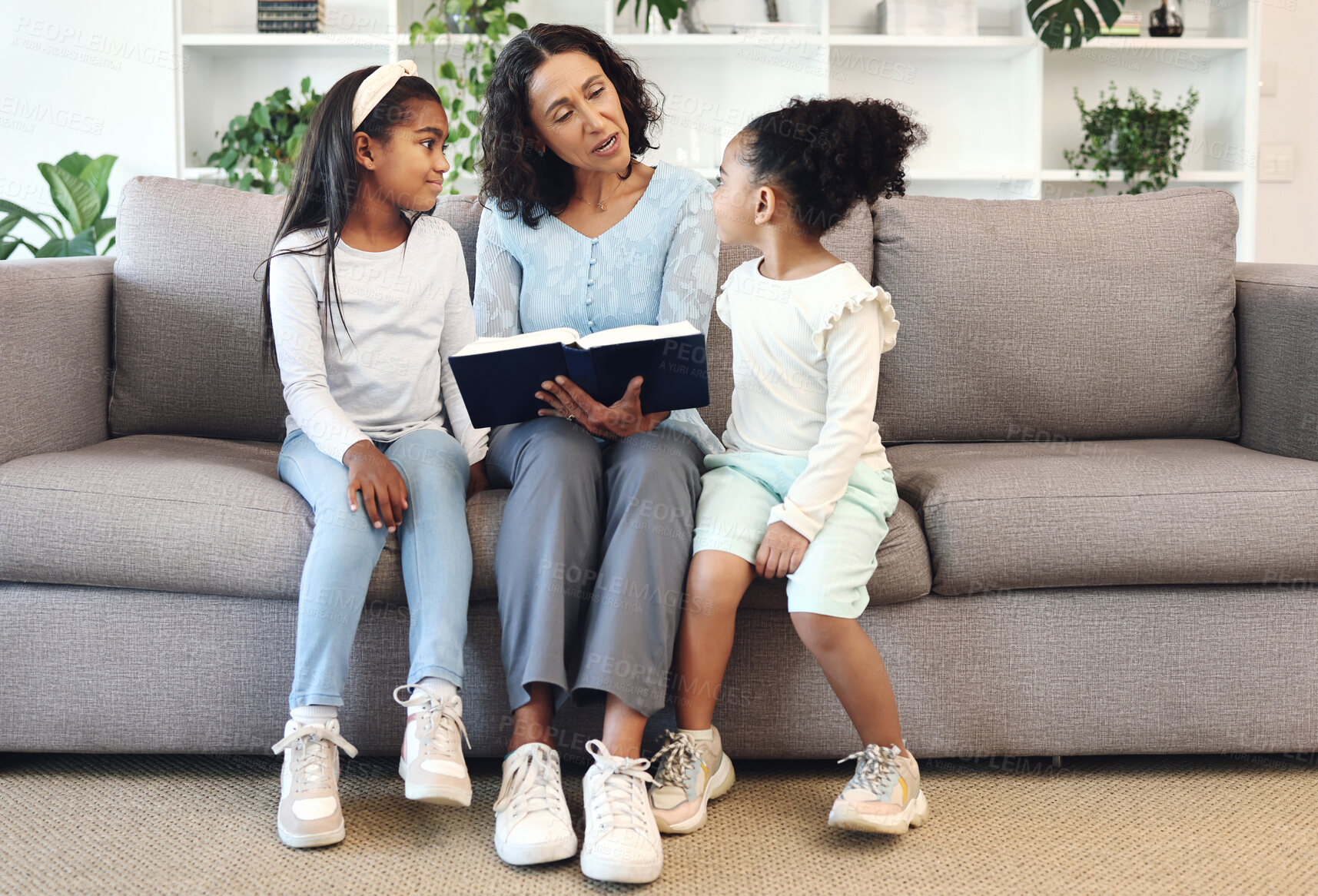 Buy stock photo Religion, book and children or family reading, teaching and learning bible story, knowledge and education in living room. Grandmother on sofa with holy scripture, gospel or history of god for kids