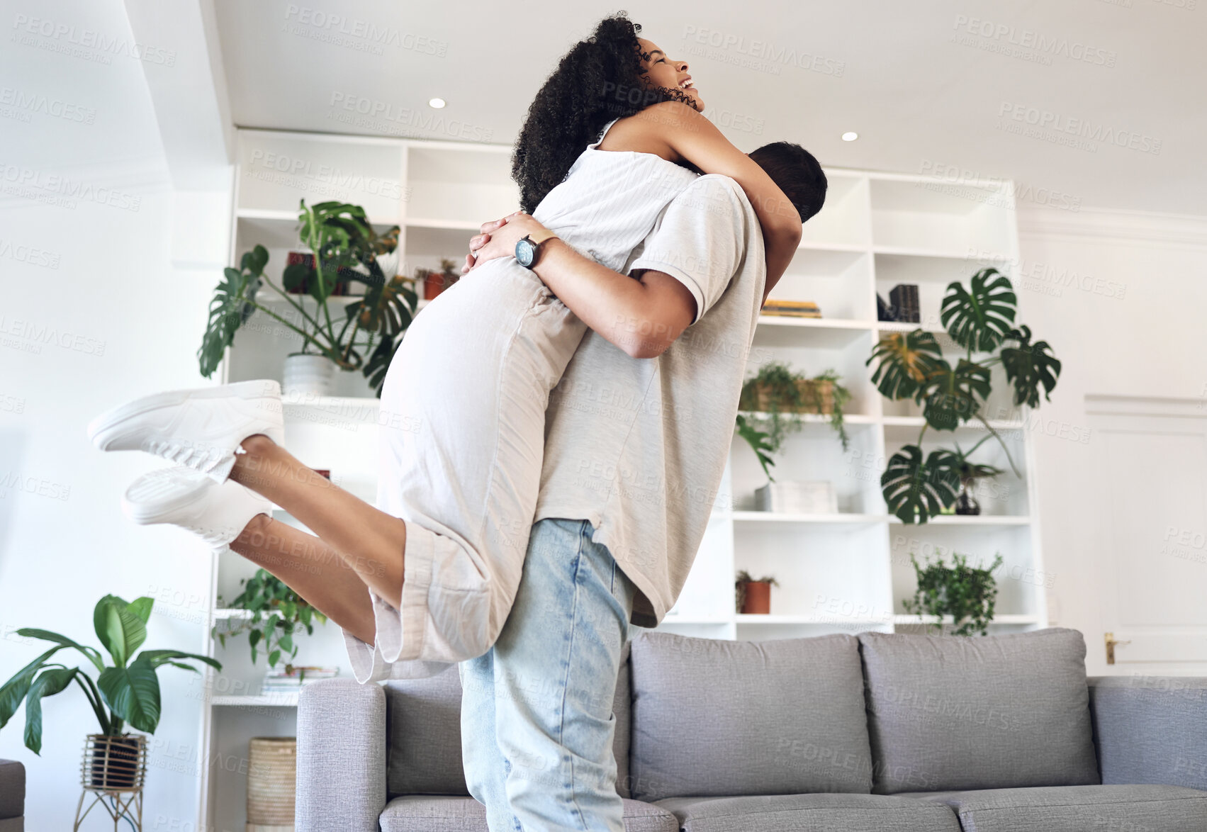 Buy stock photo Young couple, hug and jump in new house, real estate and apartment lounge with love. Happy homeowners hugging to celebrate in living room, property investment and dance with care, energy or happiness