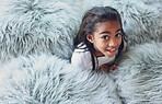 Relax, happy and portrait of a child with pillows in her modern bedroom in her home. Happiness, smile and girl kid resting, having fun and being playful with fluffy blankets in her room at a house.